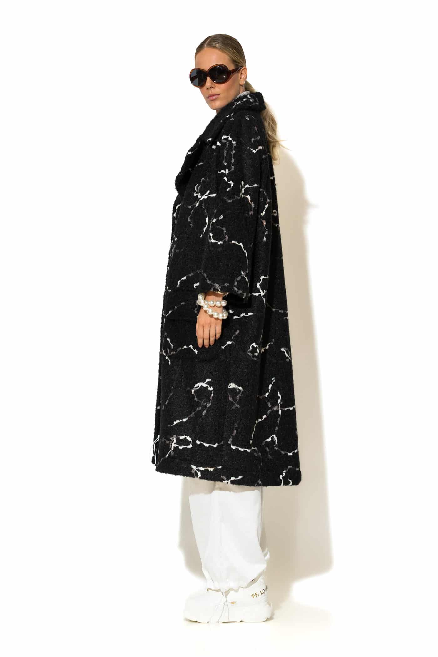 Black bouclé coat – side view highlighting texture and tailored fit