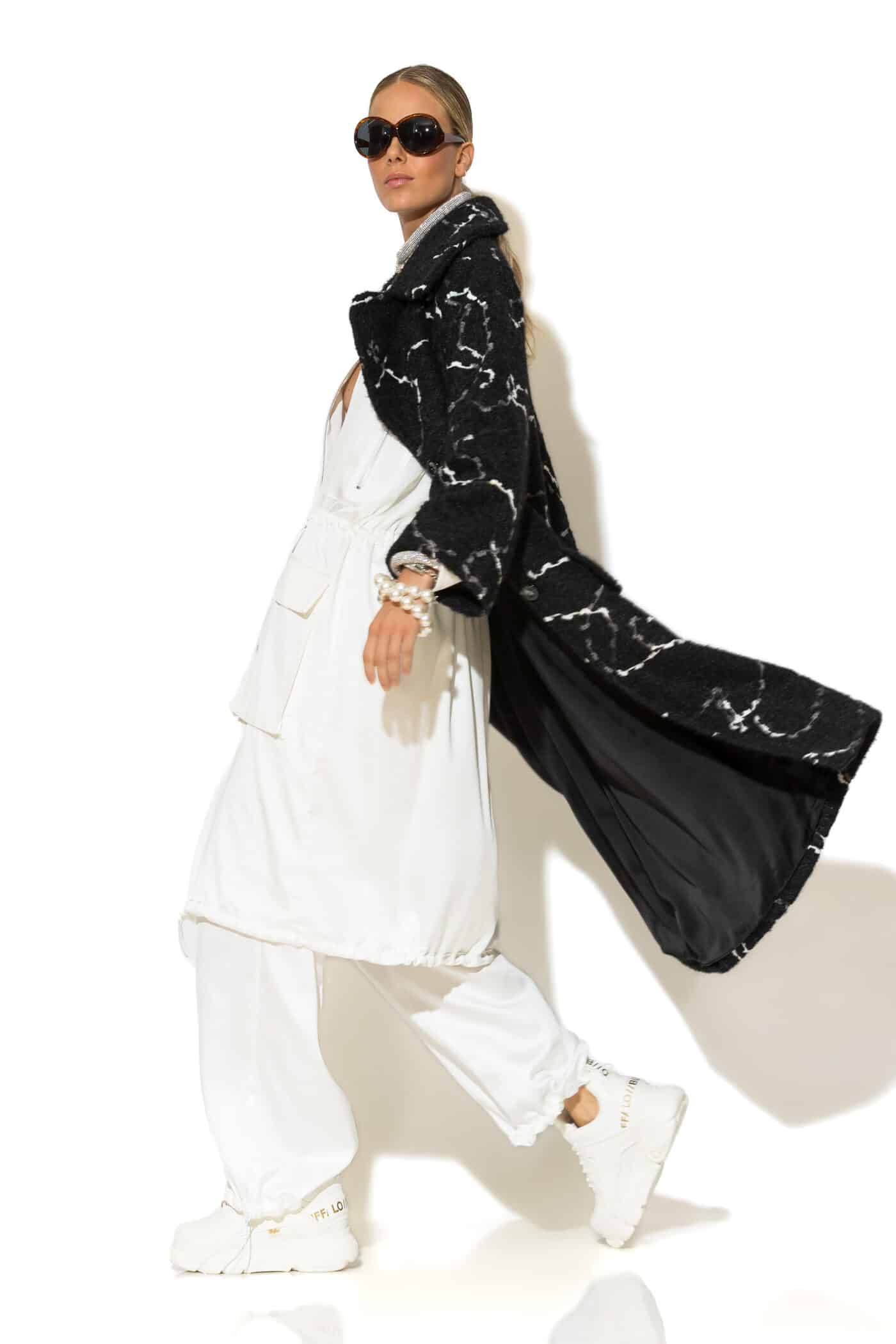 Side view of black bouclé coat with long sleeves and mid-calf length