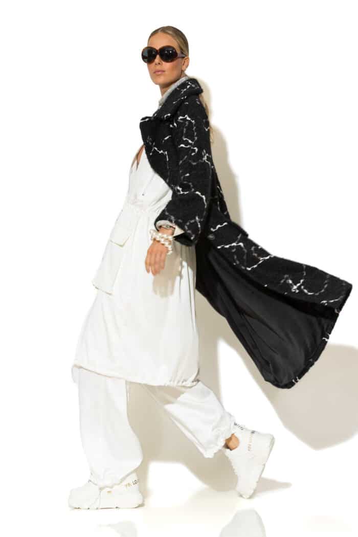 Side view of black bouclé coat with long sleeves and mid-calf length