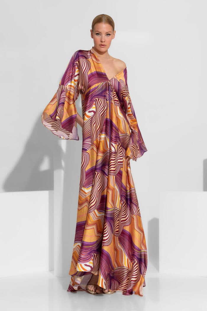 A mesmerizing satin creation featuring a vibrant abstract pattern, a flattering V-neckline, and dramatic wide sleeves. This maxi dress exudes bohemian luxury with its voluminous silhouette and fluid movement, making it an ideal choice for high-end summer events and evening appearances.