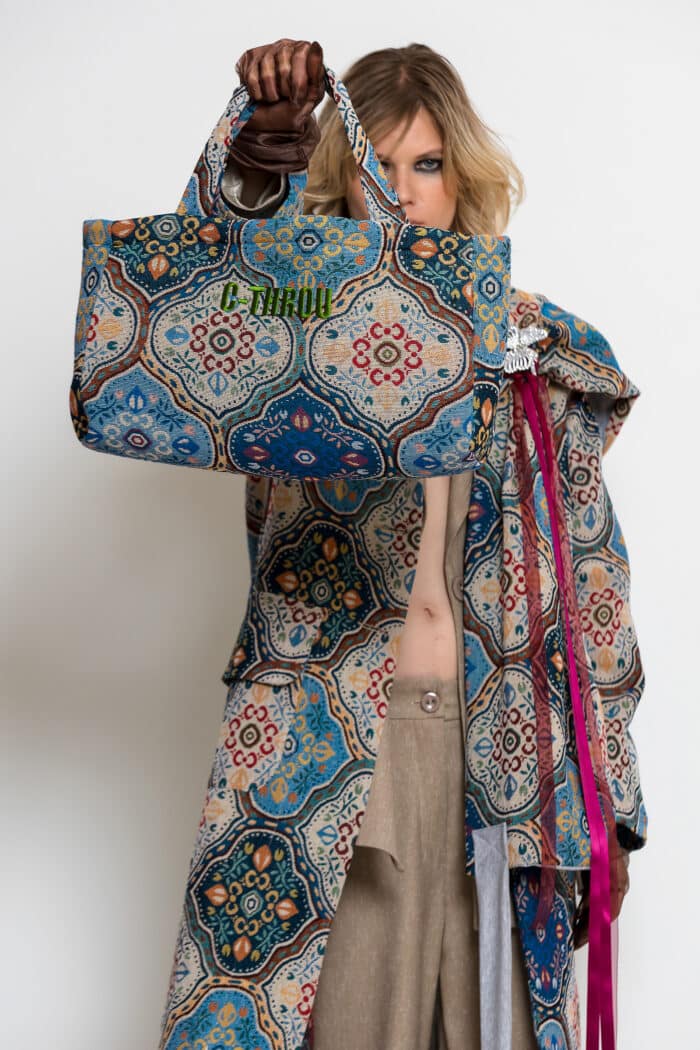 Multicolour brocade medium tote bag with ornate blue and turquoise pattern, matching handles and green embroidered logo.